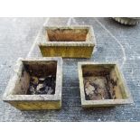 Two square reconstituted stone garden planters and one rectangular.