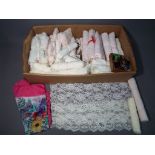 A box containing a quantity of lacework, sewing accessories,