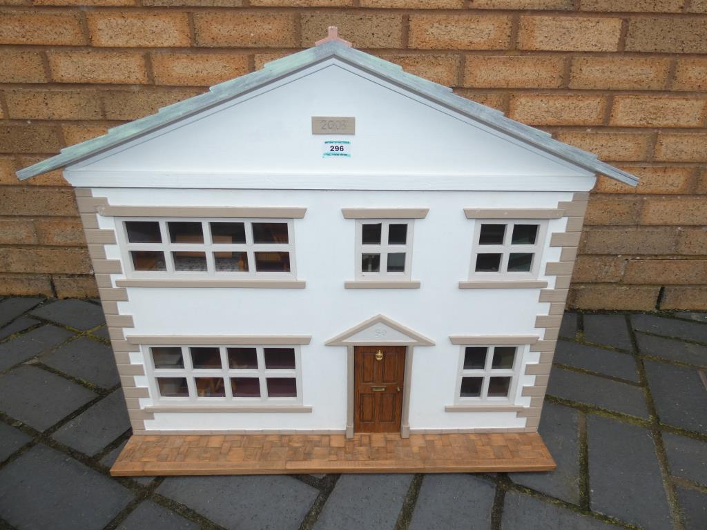 A wooden dolls house with accessories measuring approximately 57 cm x 72 cm x 38 cm.