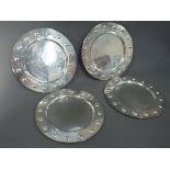 A set of four Mexican sterling silver service plates, plain inner, the borders with embossed detail,