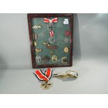 A glass cased collection of fourteen medals and badges bearing Third Reich emblems,