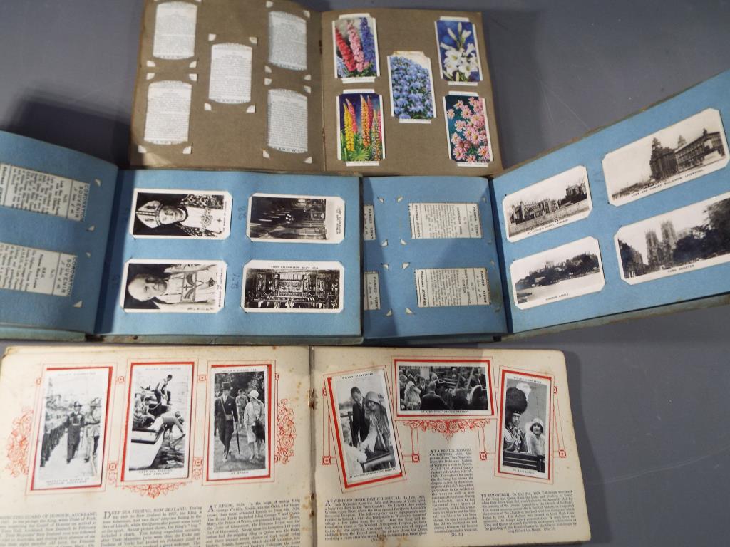 Four cigarette card albums containing complete sets of famous UK landmarks,