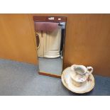 A wash bowl and jug with floral decoration and a mirror.