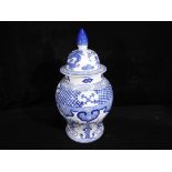 A late 19th century large covered urn shaped vase hand painted in blue and white,