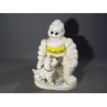 A cast iron advertising figure, depicting a dog and a Michelin Man.