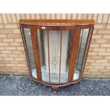 A crescent shaped display cabinet with two glass shelves,