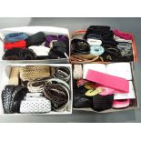 Four boxes containing a large quantity of leather and material fashion belts,