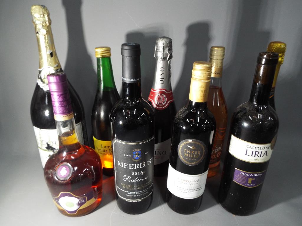 A collection of alcoholic beverages to include Prosecco, Courvoisier, red wine and similar.