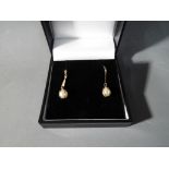 A pair of 9ct gold earrings stone set with pearls This lot must be paid for and removed no later
