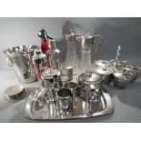 A quantity of silver plated ware to include silver plated claret jugs, cocktail makers,