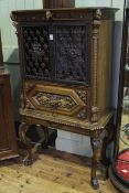 Continental carved wrought metal two door cabinet on stand with leaded glass back,