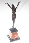 Bronze figure of a dancer with outstretched arms on marble plinth,