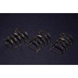 Three silver five bar toast racks,