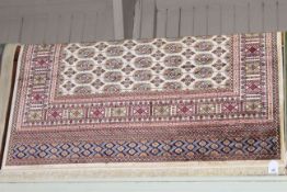 Bokhara carpet with a beige ground 2.30 by 1.