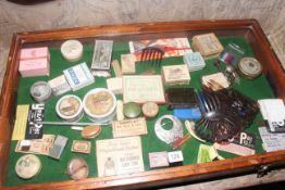 Counter top display case, possibly for a ladies vanity shop, items include talcs, slides, brooches,