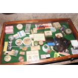 Counter top display case, possibly for a ladies vanity shop, items include talcs, slides, brooches,
