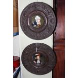 Pair of porcelain portrait plaques in embossed metal frames,