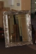 Ornate silvered framed bevelled wall mirror,