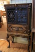 Continental carved wrought metal two door cabinet on stand with leaded glass back,