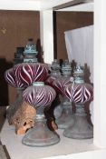 Six oil lamp bases each with ruby and white streaked reservoirs