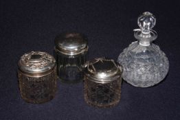 Three silver topped jars and a scent bottle,