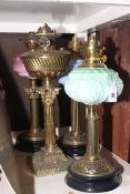 Four brass column oil lamps,