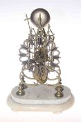 Brass skeleton clock on marble base,