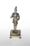 Brass military soldier wearing full uniform, presented on a four footed stand,