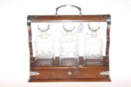 Oak tantalus with three decanters plus three plated decanter labels,