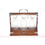 Oak tantalus with three decanters plus three plated decanter labels,