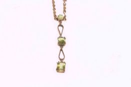 Triple peridot pendant on gold rope twist necklace