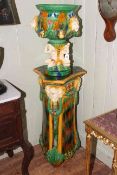 Majolica style jardiniere on stand decorated with lions and figures,
