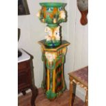 Majolica style jardiniere on stand decorated with lions and figures,