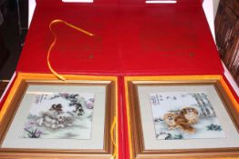 Two Oriental cased plaques decorated with Pekingese dogs,