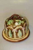 Majolica style stilton cover and stand decorated with garden scene,
