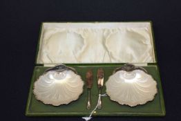 Cased pair of silver shell shaped butter dishes,