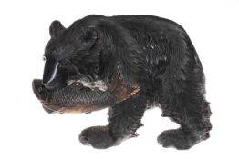 Carved wood grizzly bear carrying a fish in it mouth,