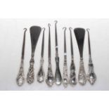 Collection of silver handled button hooks and shoehorns.