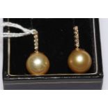 14 carat White Gold Pearl and Diamond earrings featuring, two light gold Cultured South Sea Pearls,