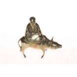 Inlaid brass Chinese elder seated on a buffalo, 14cm.