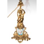 Ornate gilt metal and porcelain lamp base decorated with cherub.