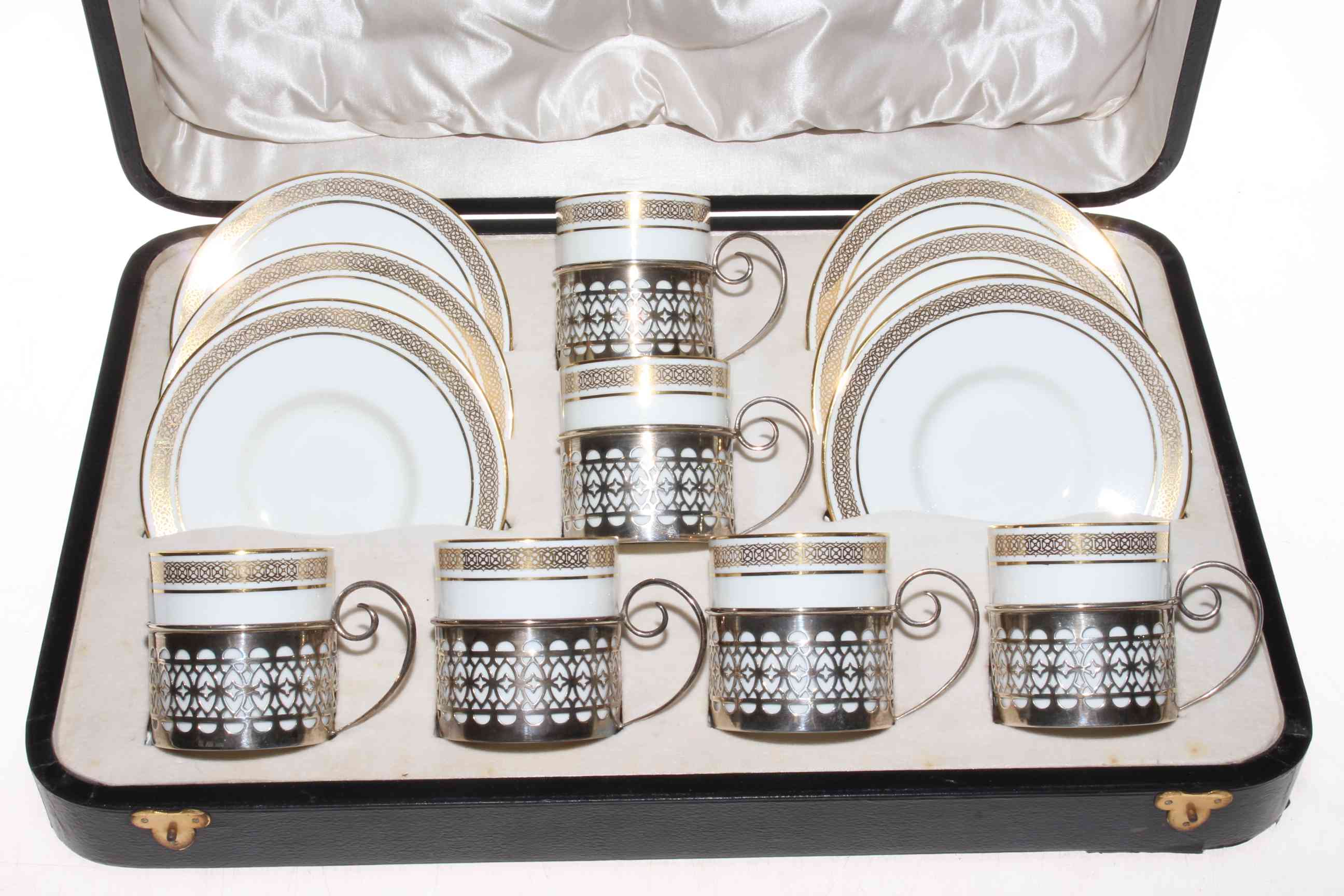 A set of six Aynsley coffee cans and saucers, each cup in pierced silver holder, Birmingham 1911,