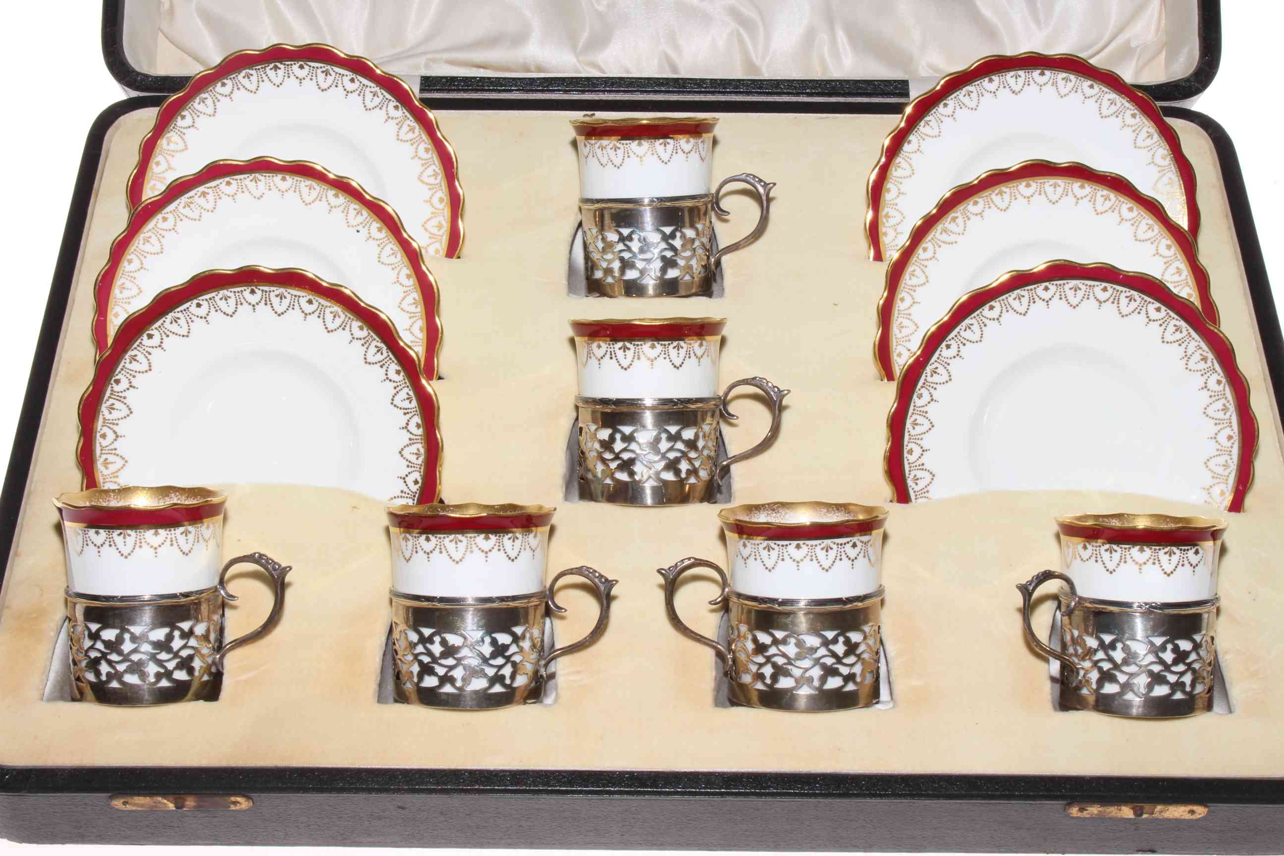 A set of six Wedgwood coffee cans and saucers, each cup in pierced silver holder,