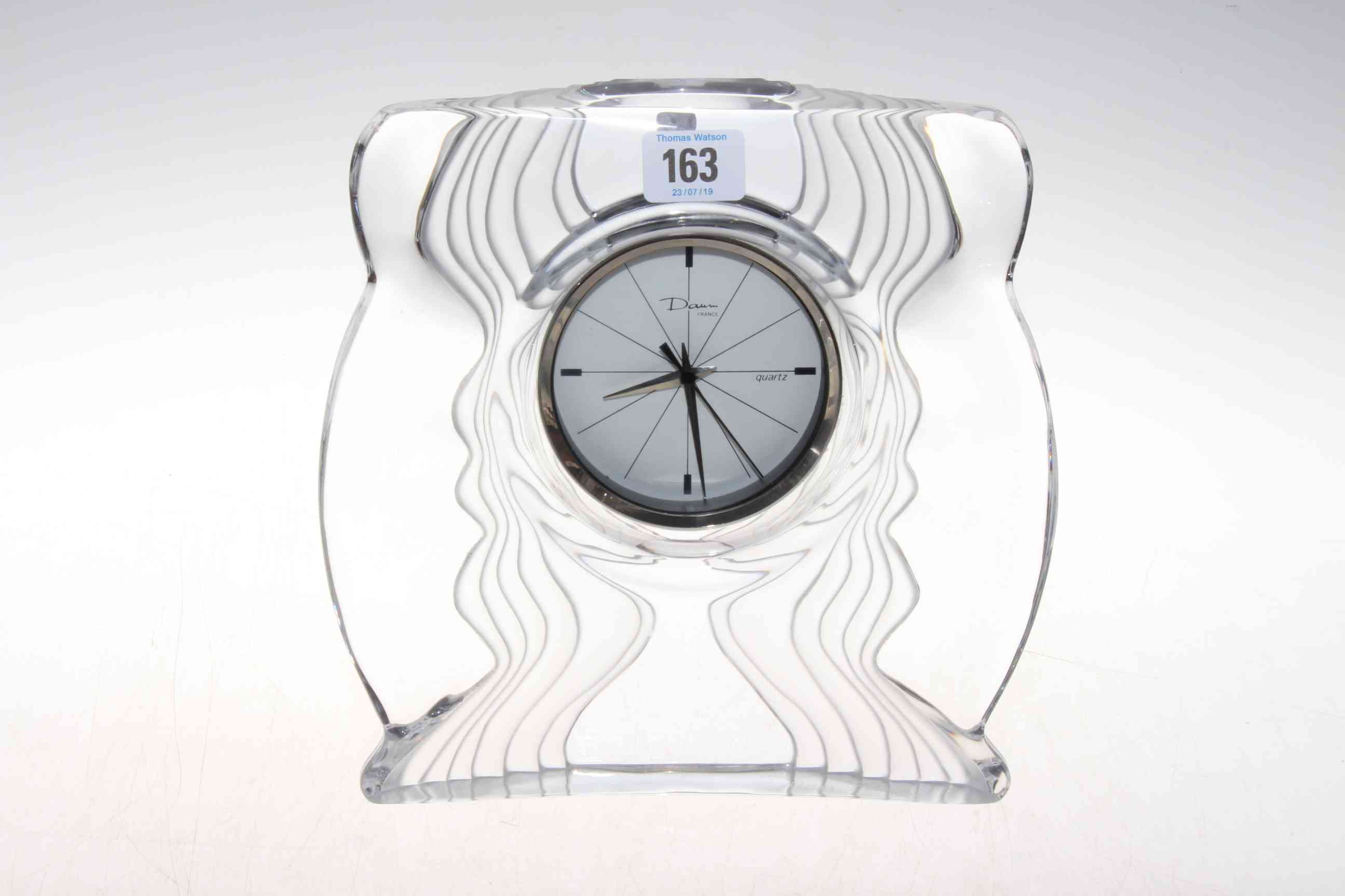 Daum glass mantel clock, the circular quartz movement in wavy sided and shaped case,