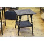 Carved ebonised two tier occasional table, 65cm by 52.5cm.