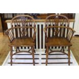 Pair Windsor elm pierced splat back elbow chairs with crinoline stretchers.