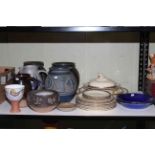 Shelf of stoneware planters and jugs, ceramic plates and tureen.