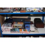 Shelf of books, postcards, stamps, covers, Ordnance Survey maps, binoculars, leather case.