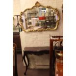 Polished mahogany serpentine front console table and shaped gilt framed wall mirror.