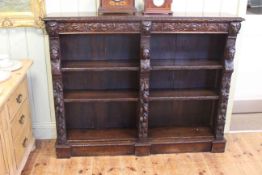 Heavily carved oak open bookcase carved with lion masks and figure heads,